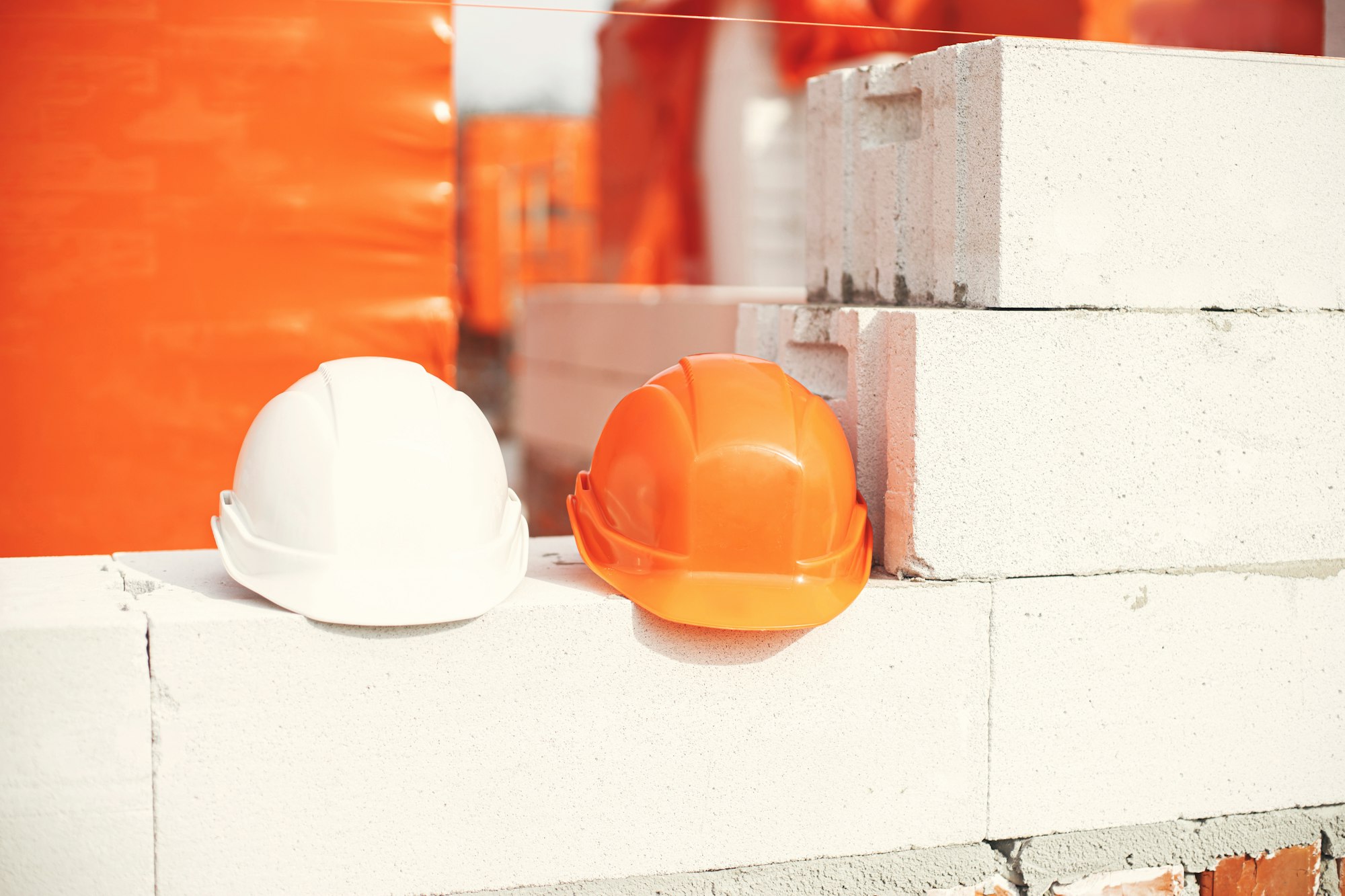 Safety helmets on masonry white blocks. Architecture and development. House building concept