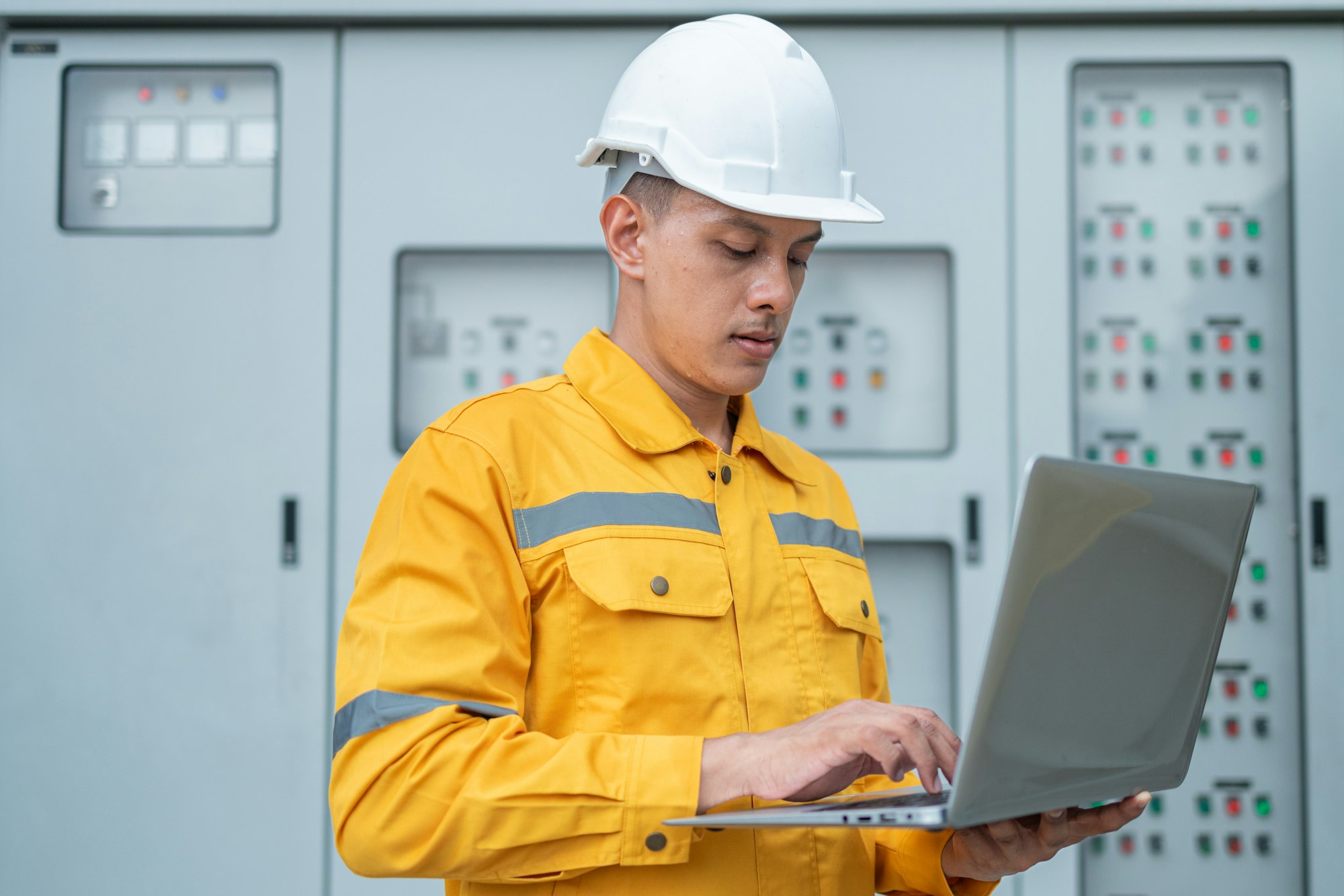 Electrical Engineer Monitoring Systems on Laptop